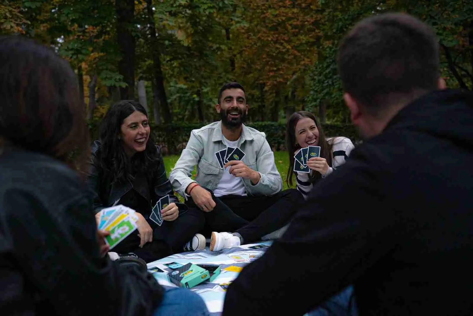 Grupo de amigos jugando a las cartas en un parque